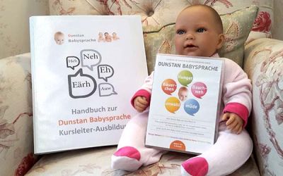 Babyähnliche Puppe auf einem Sessel mit Babysprache-Material