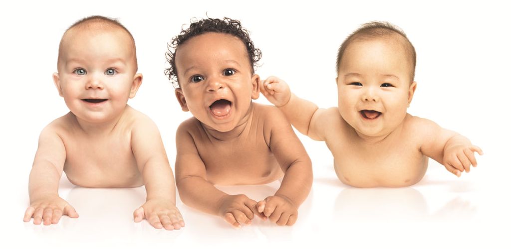 Drei Babys liegen unbekleidet auf dem Bauch, schauen fröhlich den Betrachter an